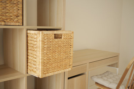 Home office storage solution with woven basket and wooden deskの写真素材