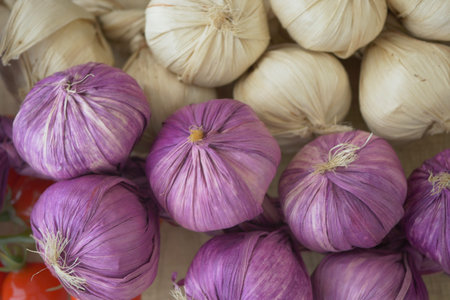 Colorful garlic bulbs displayed at a local market in the afternoonの写真素材