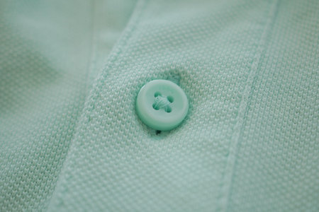 Close-up of a mint green button on textured fabric