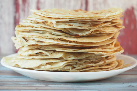 Stack of freshly made flatbreads on a plate in a cozy kitchenの写真素材