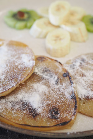 Delicious pancakes served with fresh fruit on a sunny morningの写真素材
