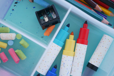 Colorful art supplies organized in a craft box on a bright surfaceの写真素材