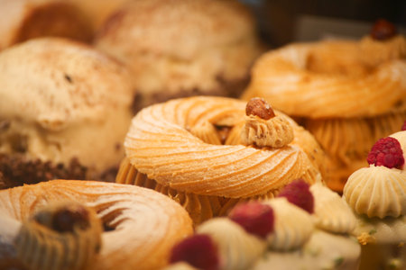 Sweet pastries displayed in a bakery showcasing various designsの写真素材