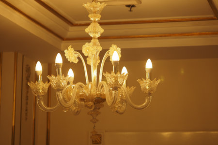 Elegant chandelier with warm lighting in a luxurious interiorの写真素材
