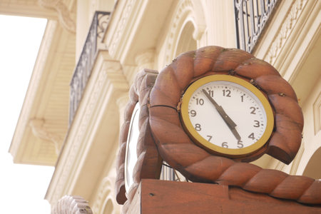 Vintage wooden clock displays time on an architectural buildingの写真素材