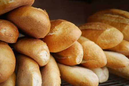 Freshly baked bread rolls displayed in a bakeryの写真素材
