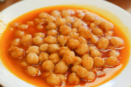 Spicy chickpea dish served in a bowl at a vibrant restaurantの写真素材