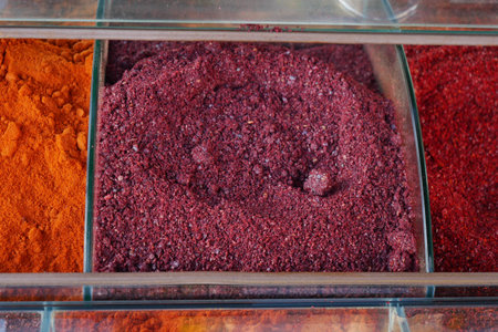 Colorful spices arranged in clear containers at a market stallの写真素材