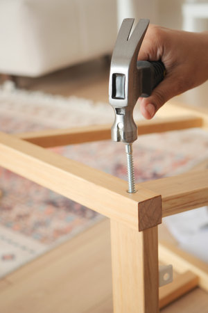 Hand assembling furniture with tools in a cozy interior spaceの写真素材