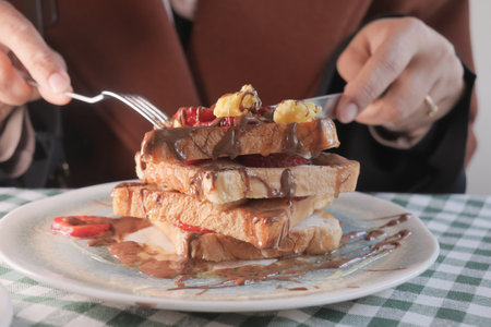Delicious stack of French toast topped with fruit and syrupの写真素材