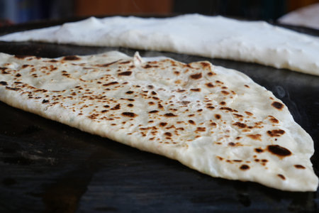 Delicious turkish Gozleme flatbreads cooking on a hot griddle