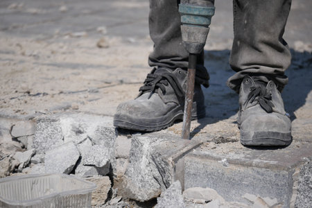 Construction worker breaking concrete on a renovation siteの写真素材