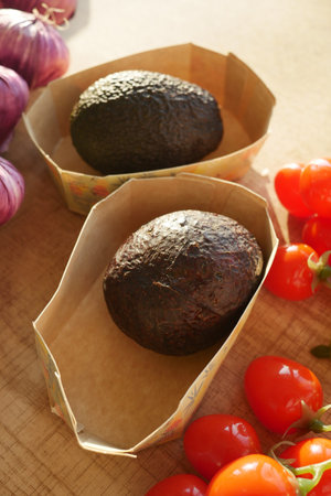 Fresh avocados and cherry tomatoes displayed on a wooden table