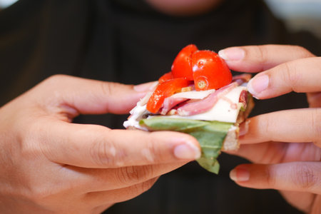Delicious open sandwich topped with fresh ingredients in handの写真素材