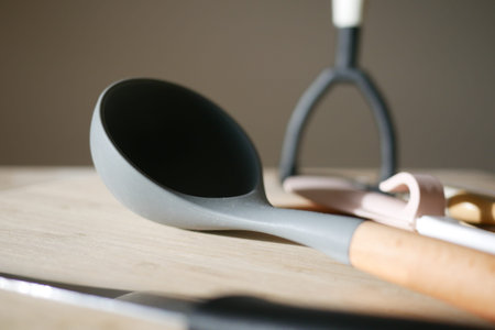 Kitchen utensils arranged on a wooden surface in soft lighting