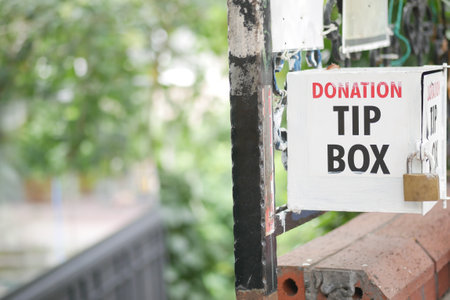 Donation tip box located in a community area with greeneryの写真素材