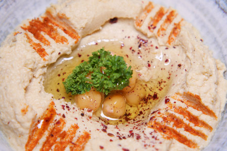 Delicious hummus with olive oil and spices garnished with parsleyの写真素材