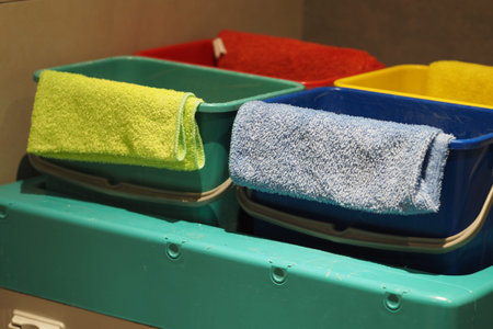 Colorful bins organized with towels in a cleaning area