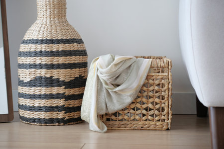 Stylish woven basket with scarf in modern interior settingの写真素材
