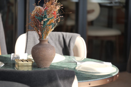 Dining table set with decorative vase and flowers in a restaurant