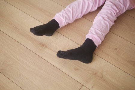 Child resting on the floor in cozy pink pajamas