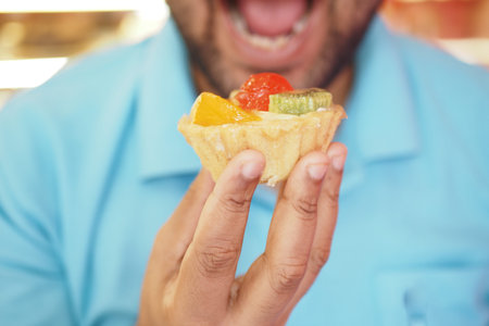 Holding a colorful fruit tart in a cheerful atmosphere