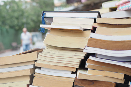 Books stacked outside a shop in a busy urban area