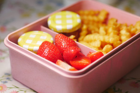 Delicious lunchbox with strawberries and crinkle fries