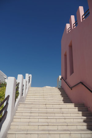 Stairs leading to a clear blue sky in a bright settingの写真素材