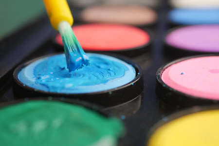 Colorful art supplies displayed with a brush applying paintの写真素材