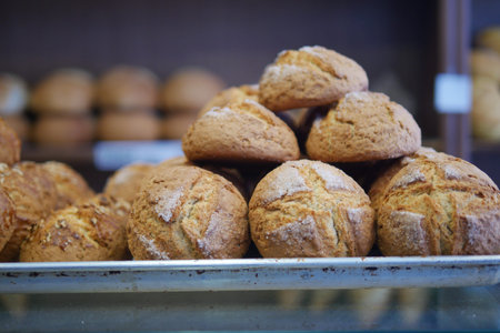 Freshly baked brown bread rolls in a bakery display