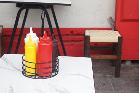 Condiment bottles on a table in vibrant outdoor setting