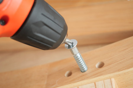 Close-up of power tool driving a screw into wood
