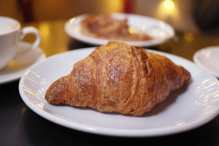 Freshly baked croissant served on a white plateの写真素材