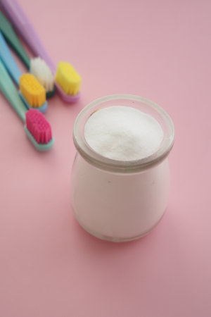 baking soda and tooth brush on pink backgroundの写真素材