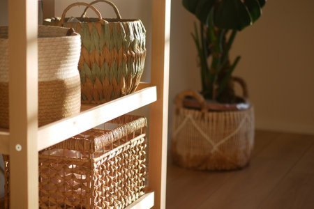 Baskets arranged on wooden shelf in a sunlit roomの写真素材