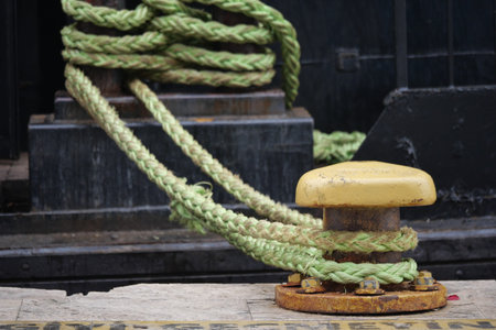 Mooring line secured at harbor dock with yellow cleat