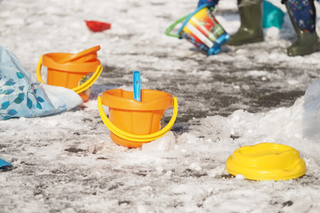 Colorful buckets by snowy ground in winter funの写真素材