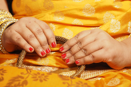 Beautiful hands adorned with jewelry in vibrant attireの写真素材