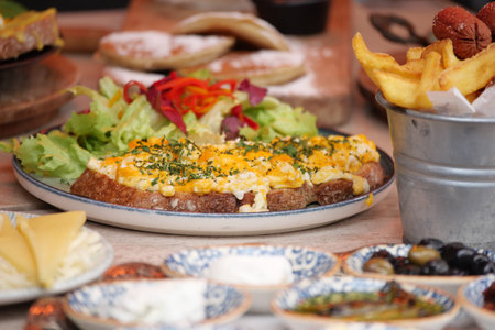 A morning meal featuring toast topped with eggs and salad on a table