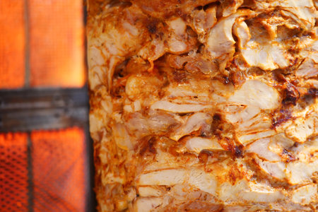 Delicious chicken cooking on a vertical rotisserie grillの写真素材