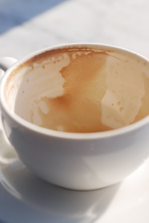 Coffee cup with remnants of beverage on a sunny morningの写真素材