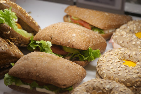 Fresh sandwiches and rolls displayed in a bakery showcaseの写真素材