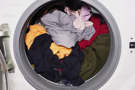 Clothes being washed in a laundry machine drumの写真素材
