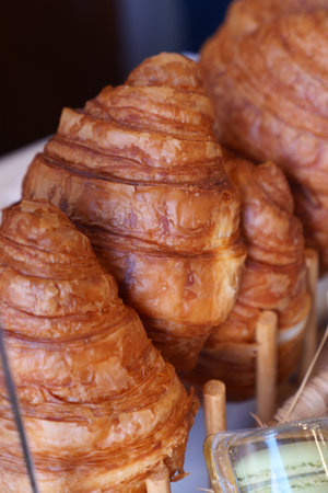 Croissants arranged on a display in a bakeryの写真素材