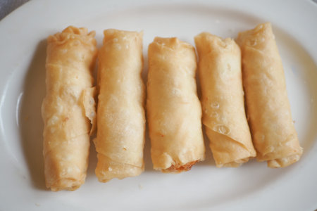 Crispy spring rolls served on a white plate for lunch