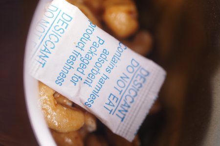 Desiccant packet among cashew nuts in containerの写真素材