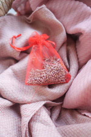 Lavender sachet resting on soft pink fabricの写真素材