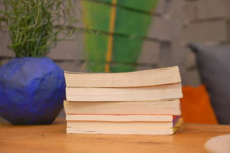 Stacked books on a wooden table with decorative elementsの写真素材