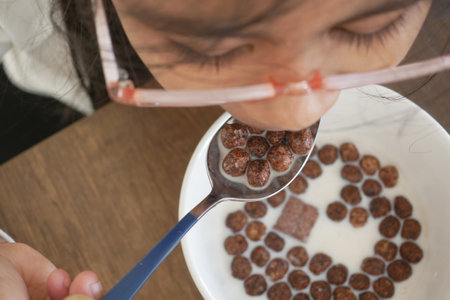 Enjoying cereal with milk during breakfast at homeの写真素材